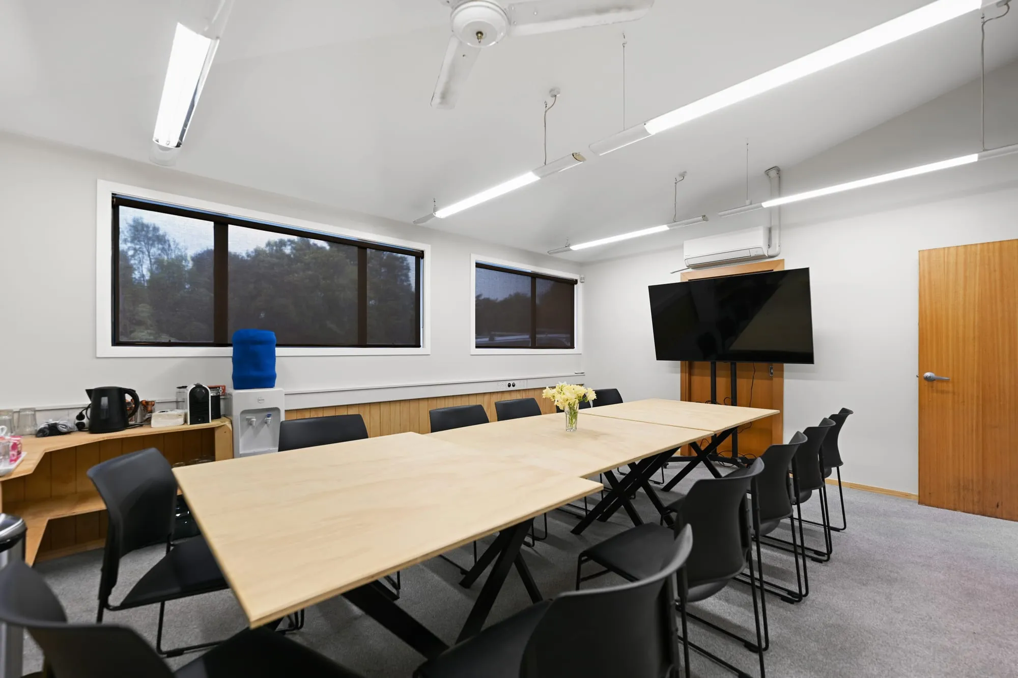 The meeting room with its 65-inch screen, water cooler and windows along one wall