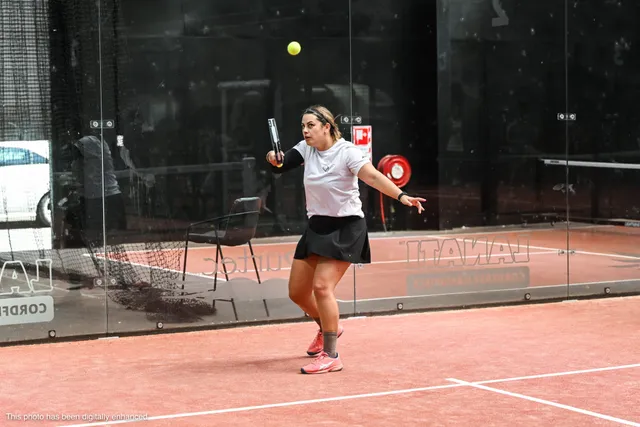 A player tracking a high ball at the back of the court