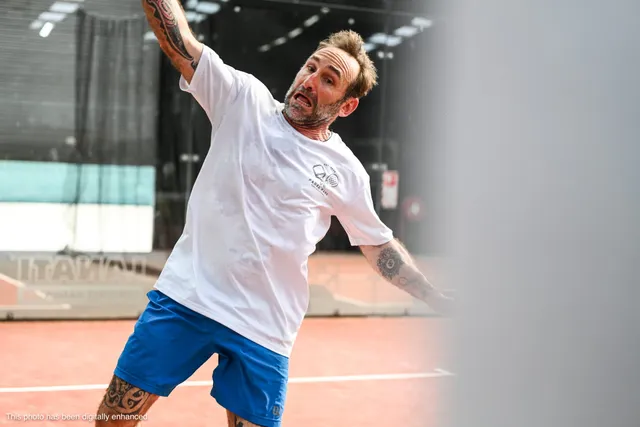 A player reaching high for an overhead