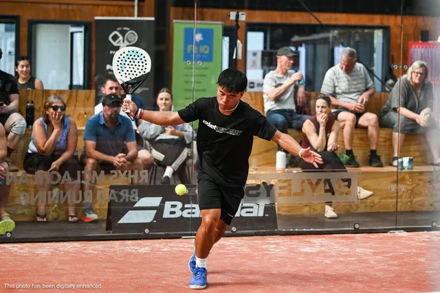 A player hitting a forehand in front of the crowd and the Babolat banner