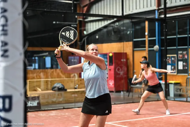 A player in a light-blue top hitting an overhead