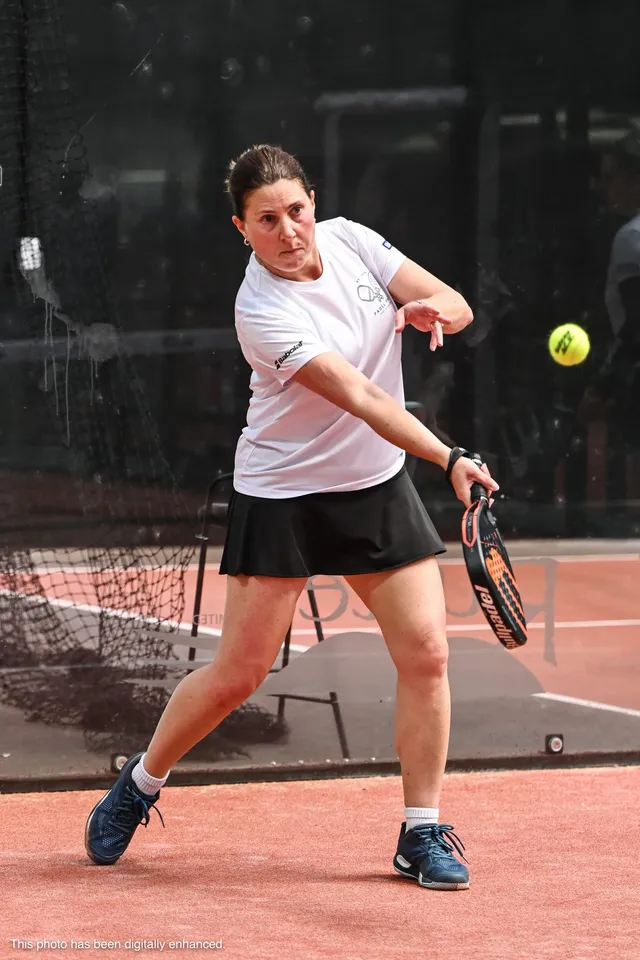 A player hitting a backhand with the ball in frame