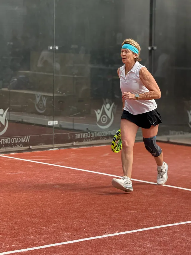 A player in a headband running across the court
