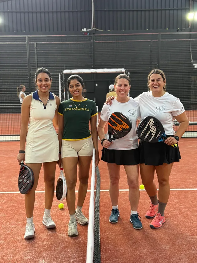 Four players smiling together at the net