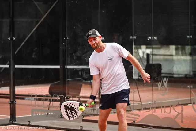A player in a cap scooping up a low forehand