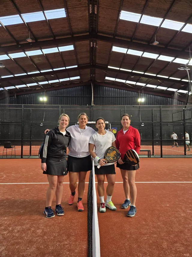 Four friends at the net after a game of padel