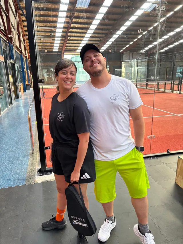 Two players smiling together beside the courts