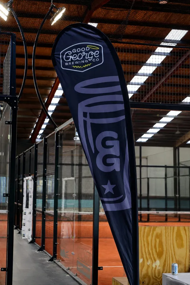An event flag standing beside the glass courts