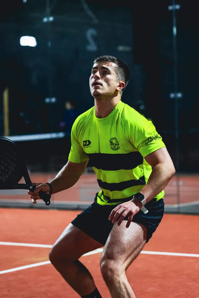 A player in yellow watching the ball come in