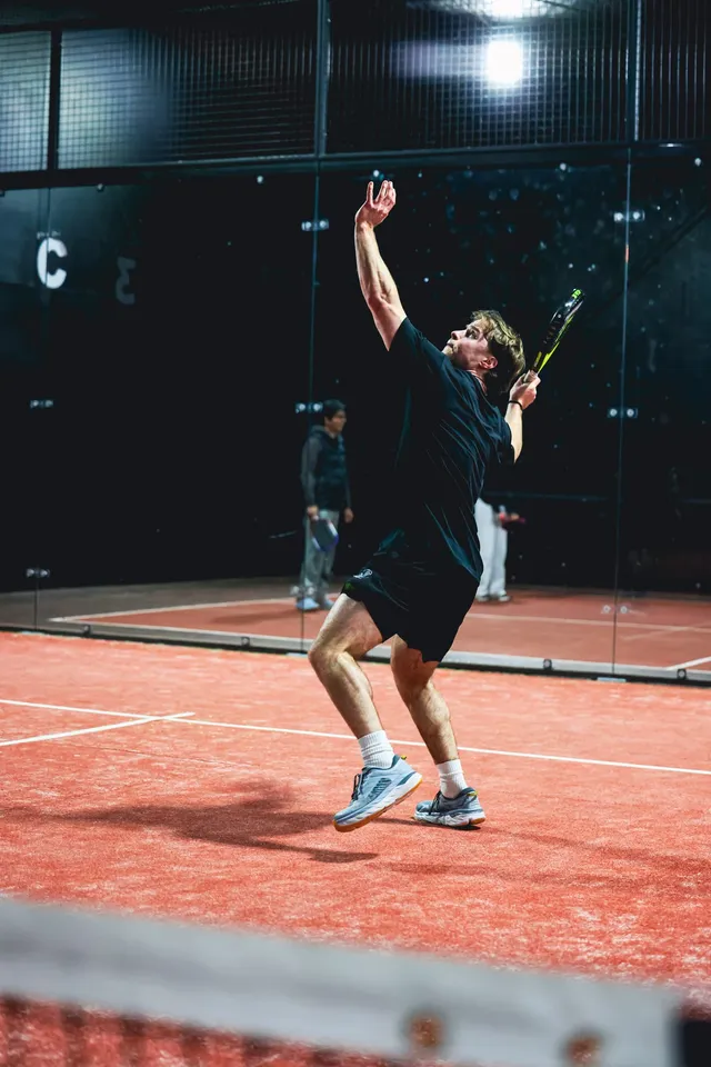 A player serving from the back of the court