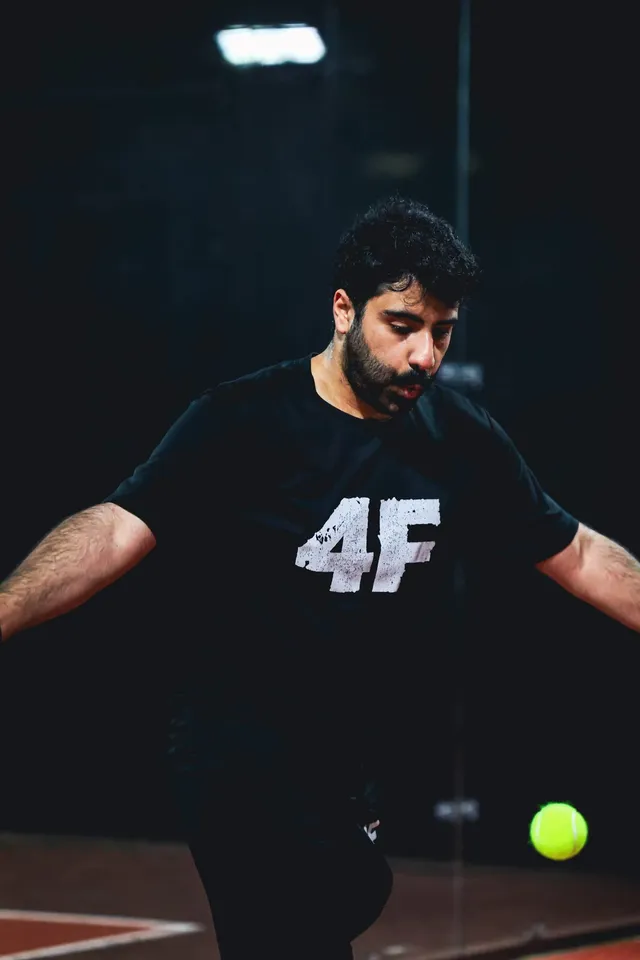 A player in black stepping in to hit the ball