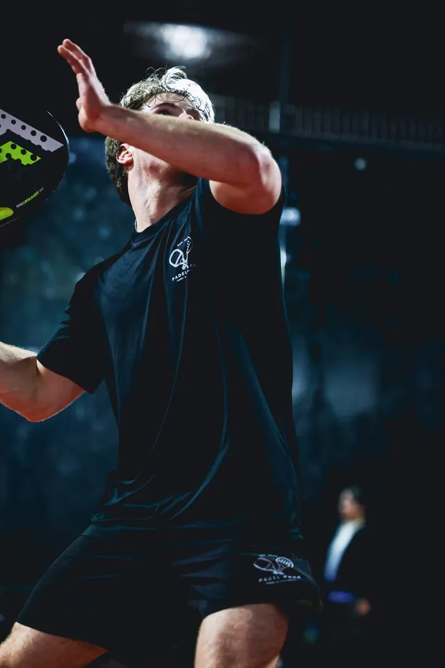 A player reaching up for the ball at the net