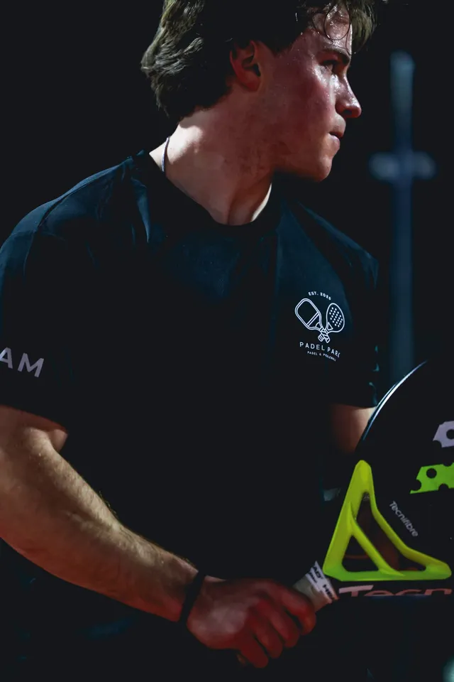 A Padel Park team member holding a padel racket