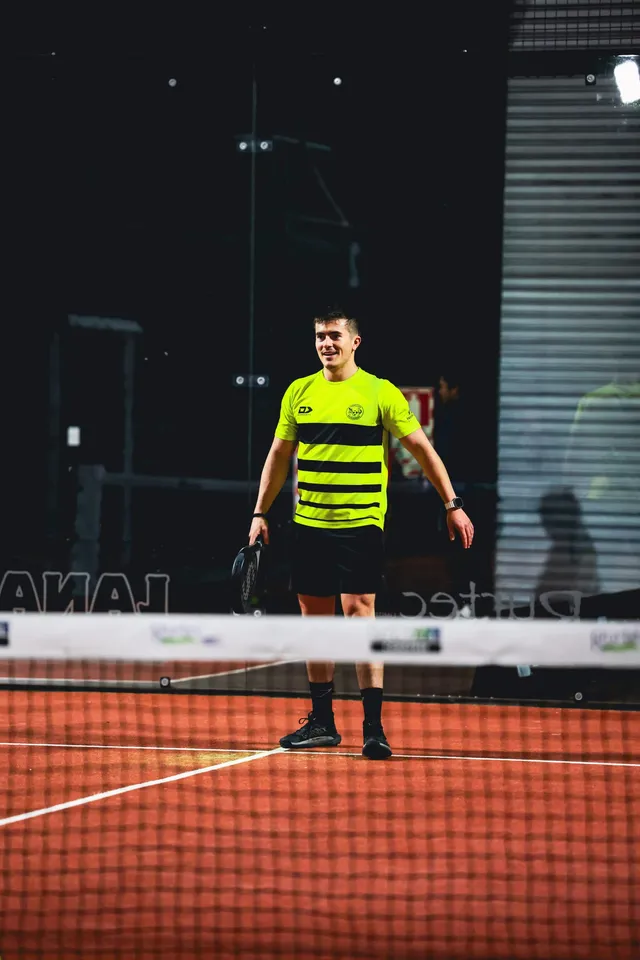A player in a bright yellow top waiting at the net