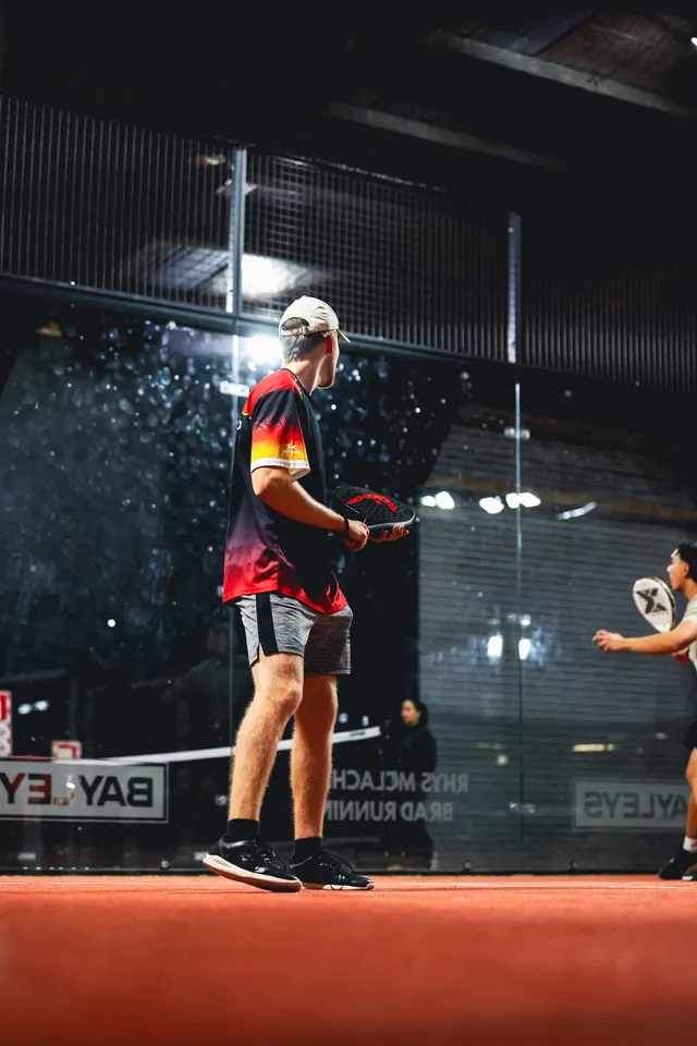 Two players mid-rally under the lights