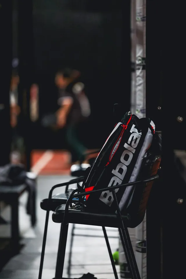 A Babolat racket bag on a courtside chair