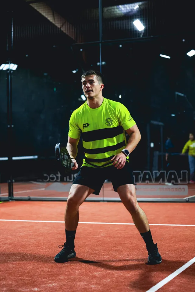 A player in yellow ready on the baseline