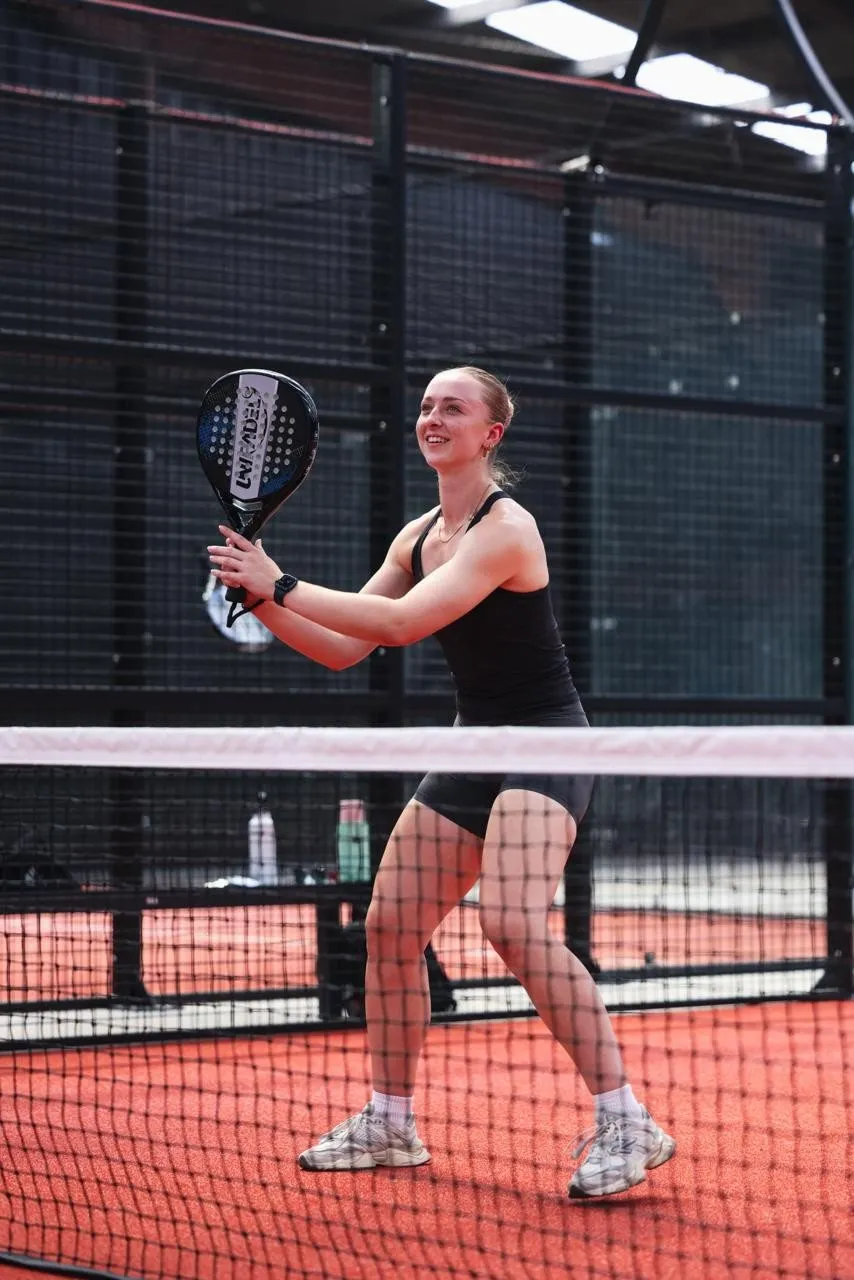 A player ready at the net on a padel court at the Park
