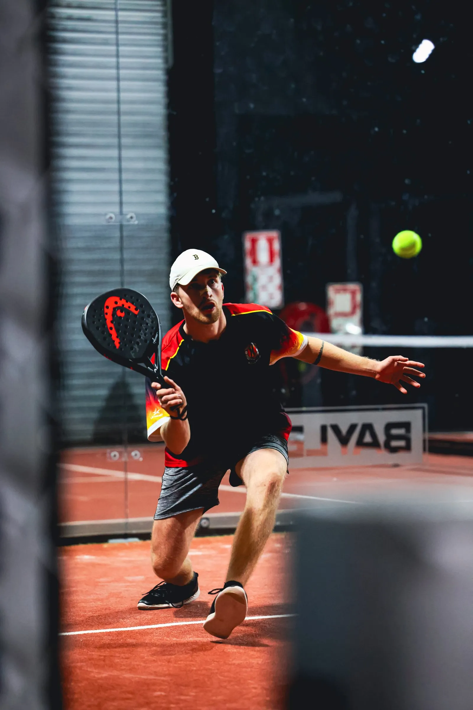 A padel player bending low for a volley on Centre Court