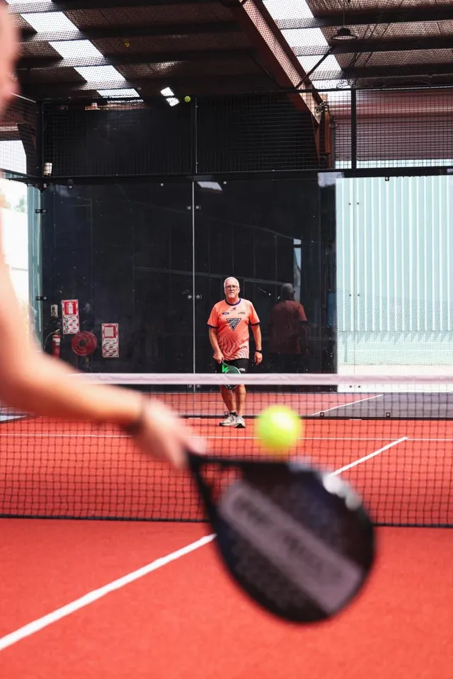A view over a player's racket as the ball comes in