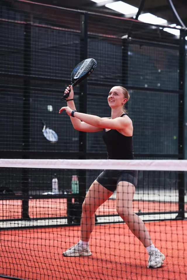 A player stretching for a forehand at the net